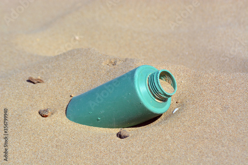 Plastic bottle pollution on a sandy beach.
