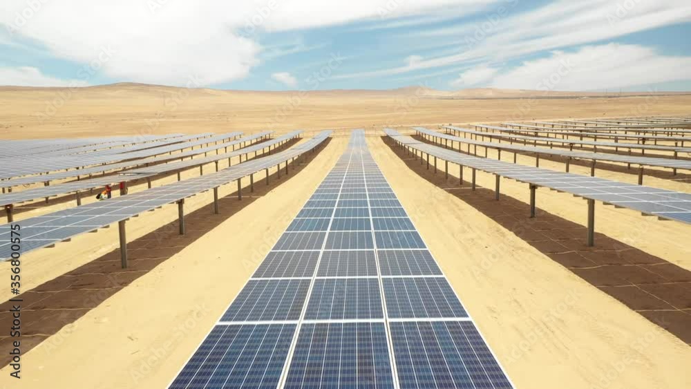 Aerial footage hundreds solar energy modules or panels rows along the dry arid lands at Atacama Desert, Chile. Huge Photovoltaic PV Plant in the middle of the desert from an aerial drone point of view