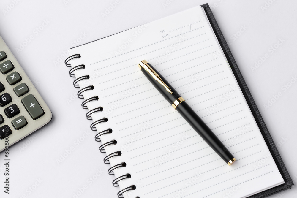 Work space on white desk with equipment office of note book, pen, calculator, Top view and copy space Work space on white desk with equipment office of note book, pen, calculator, Top view and copy space