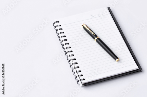 Notebook and pen on white background