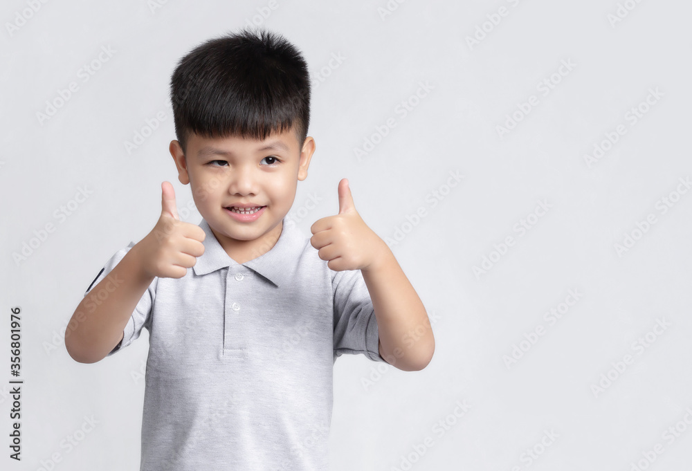 Portrait of happy Asian boy showing thumbs-up gesture. Portrait of happy Asian boy showing thumbs-up gesture.