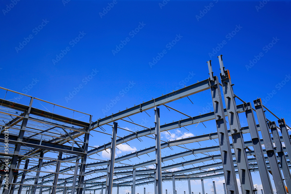 Steel frame structure factory building, in the blue sky and white clouds background Steel frame structure factory building, in the blue sky and white clouds background