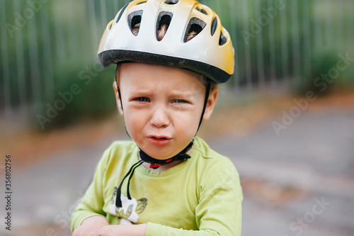 Baby boy todler in his helmet cries. he fell and hit. 