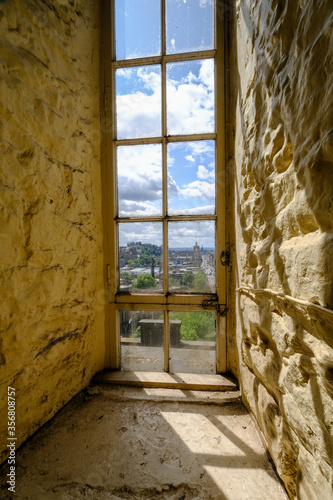 View of the Edinburgh old city through an old building window in the afternoon