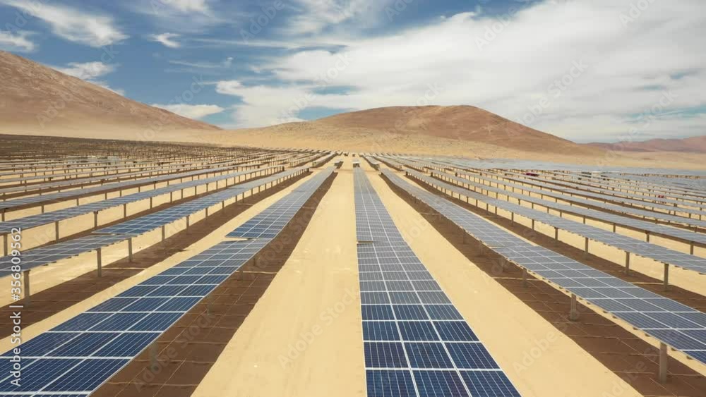 Aerial footage hundreds solar energy modules or panels rows along the dry arid lands at Atacama Desert, Chile. Huge Photovoltaic PV Plant in the middle of the desert from an aerial drone point of view