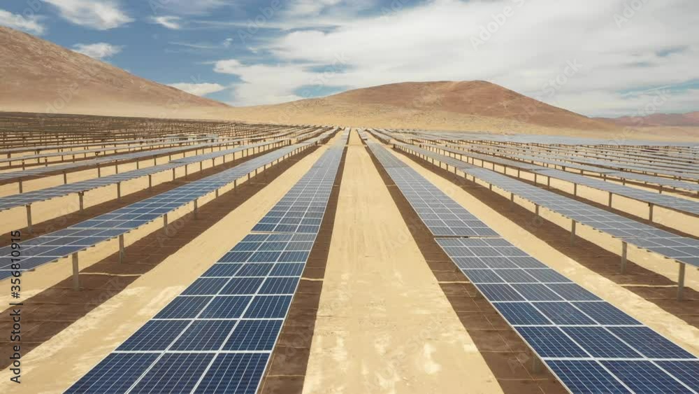 Aerial footage hundreds solar energy modules or panels rows along the dry arid lands at Atacama Desert, Chile. Huge Photovoltaic PV Plant in the middle of the desert from an aerial drone point of view