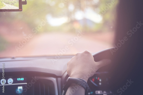 Hands on wheel, Close up woman driving car on road with sunlight warm tone for come back to home