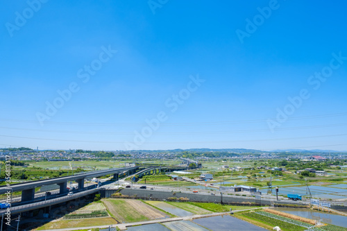 水田と鉄道のある風景　市街地　JR奈良線　京都府木津川市　初夏