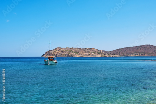 Spinalonga island in Elounda, Agios Nikolao district Cretes with a transfer ship in the foreground