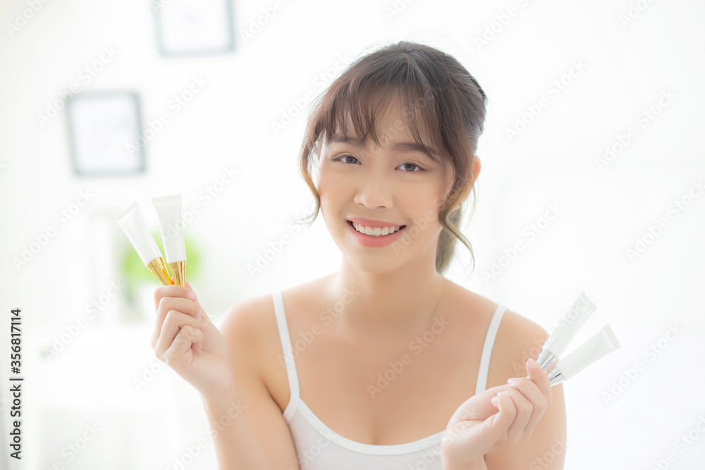 Beautiful portrait young asian woman holding and presenting cream or lotion product, beauty asia girl show cosmetic makeup and moisturizing for skin care, healthy care and wellness concept. Beautiful portrait young asian woman holding and presenting cream or lotion product, beauty asia girl show cosmetic makeup and moisturizing for skin care, healthy care and wellness concept.