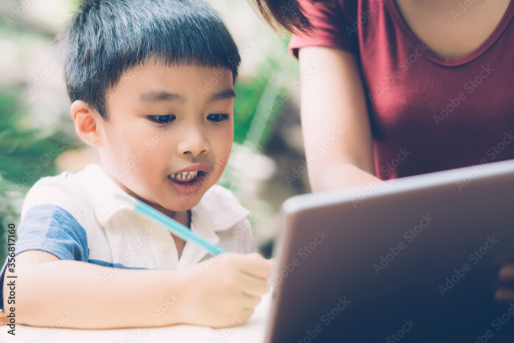 Son using digital tablet computer for study and learn to internet online with mother together, education from home, family recreation, mom teach boy and homework with technology, lifestyle concept. Son using digital tablet computer for study and learn to internet online with mother together, education from home, family recreation, mom teach boy and homework with technology, lifestyle concept.
