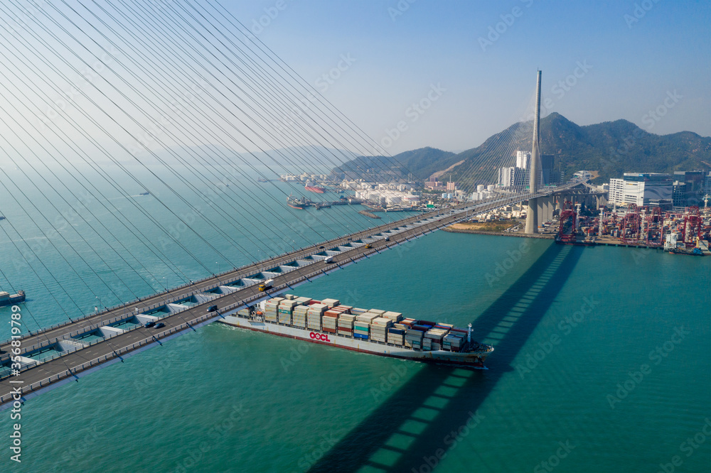 Top view of cargo ship pass though suspension bridge