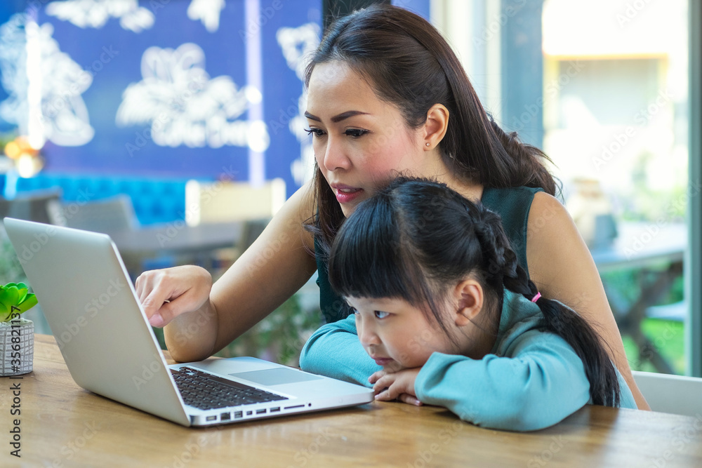 Mother and girl play computer at home Mother and girl play computer at home