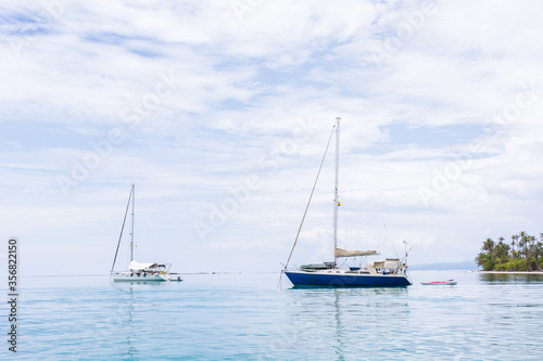 Beautiful seascape of blue sea with floating yacht and white cloud sky. luxury summer day lifestyle vacation tourism travel in Guna Yala, San Blas Islands, Panama, Central America - Horizontal wide © German