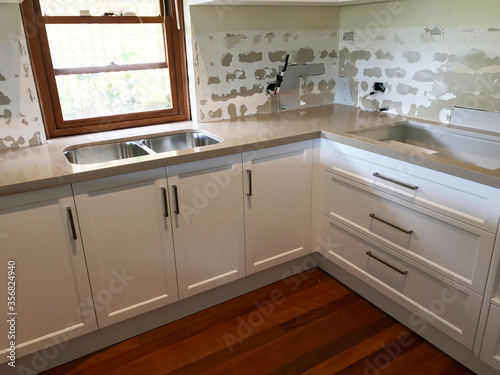 Total renovation of a kitchen with new cupboards  tiles  bench top and appliances