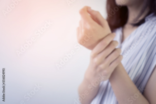 Close up woman suffering from pain in hand or wrist.