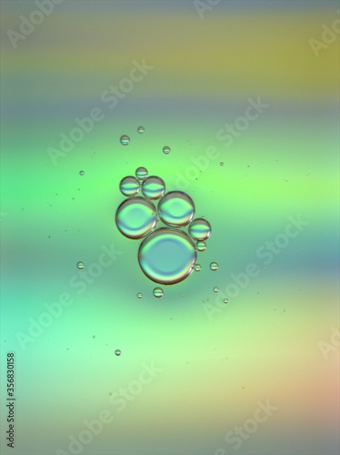 Beautiful bubbles oil with colorful green blue background ,dropslets macro image ,abstract background, sweet pastel color for card design