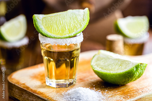 glass of tequila, a drink of Mexican culture, made of distilled alcohol, lemon, salt and blue agave. International tequila day. photo