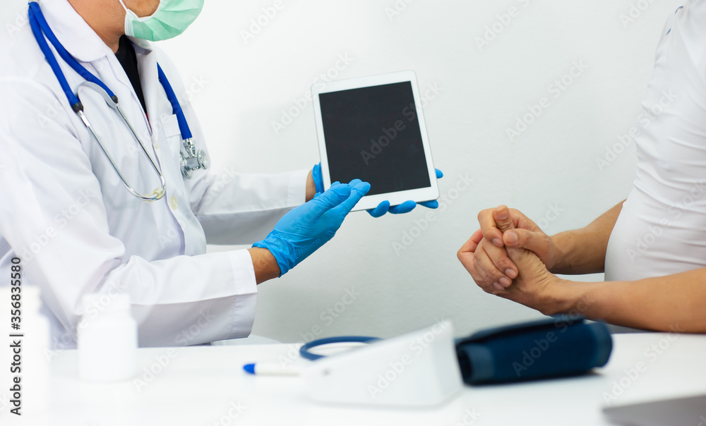The doctor held the tablet on a blank screen. Male patients see a doctor for an annual health check. The doctor held the tablet on a blank screen. Male patients see a doctor for an annual health check.