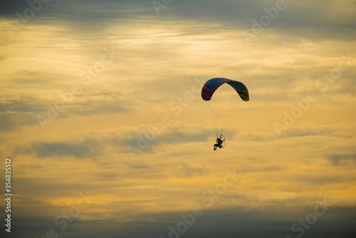 Silhouette of a paramotor in the evening sky