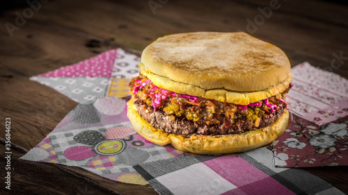 Hambúrguer de carne com cheddar molho de beterraba sobre mesa rústica sobre mesa de madeira photo