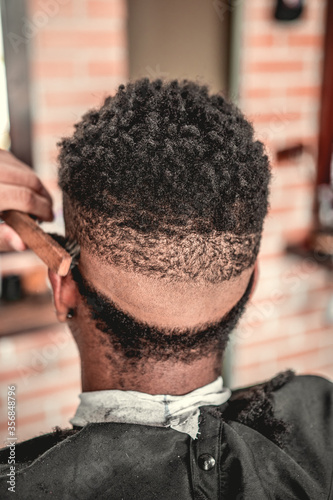 Barbeiro cortando cabelo do seu cliente da sua barbearia no estilo vintage