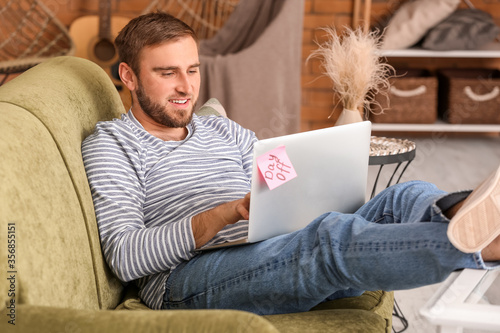 Lazy man with laptop spendi...