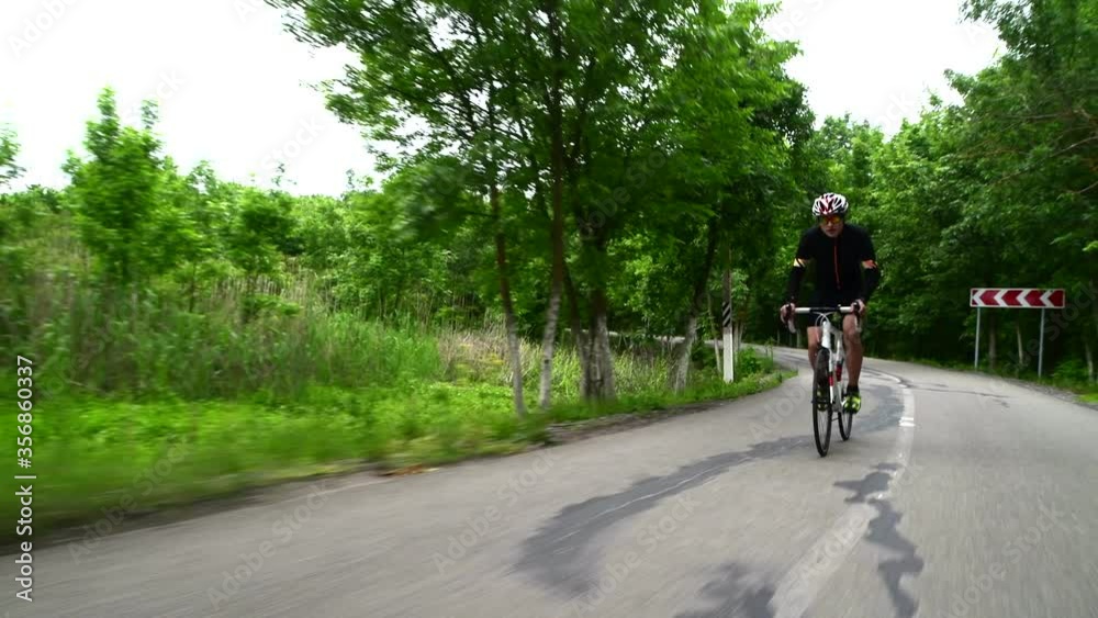 professional sportsman cycling road bike, sport concept, mountain road at sunset professional sportsman cycling road bike, sport concept, mountain road at sunset