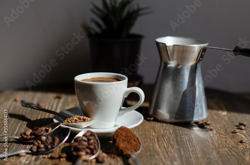 a cup of coffee on the table with different types of kefe in spoons photo