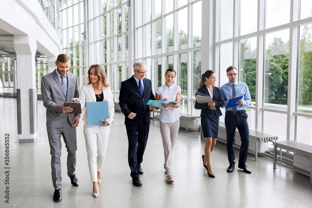 people, work and corporate concept - business team with folders walking along office building and talking people, work and corporate concept - business team with folders walking along office building and talking