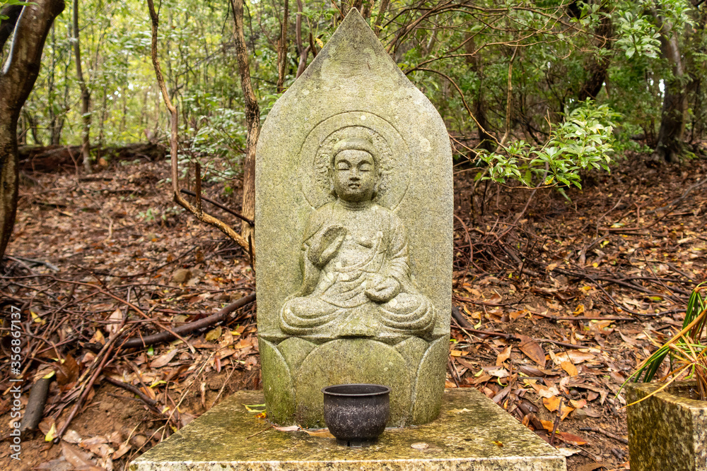 Wayside stone carved Buddha statue in japanese park in Nara, Japan.