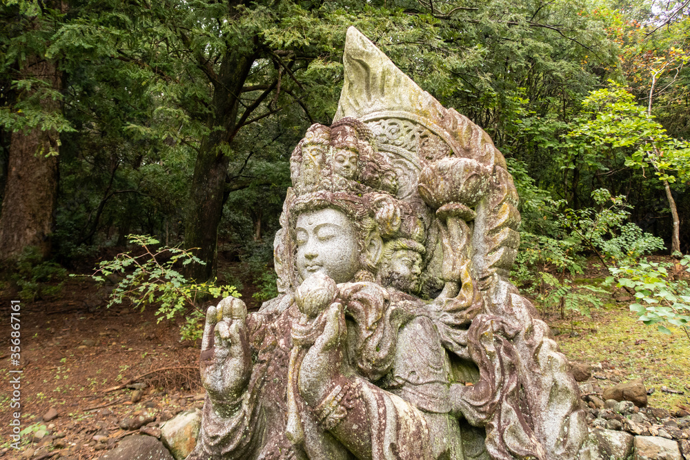 Wayside carved stone small Buddha statue in japanese  Nara park in Nara, Japan.