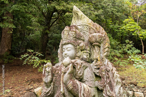 Wayside carved stone small Buddha statue in japanese Nara park in Nara, Japan.