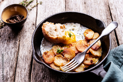 Wallpaper Mural Fried Eggs and Potatoes in cast iron skillet on rustic wooden table. Skillet Breakfast. Selective focus Torontodigital.ca