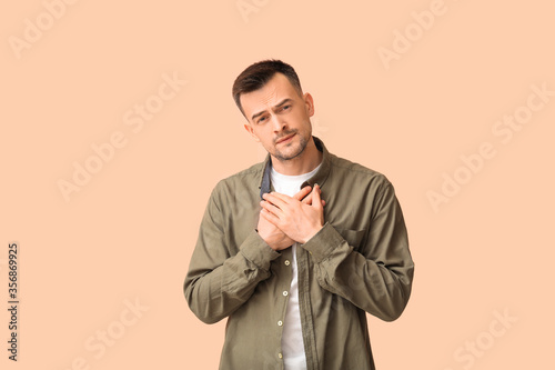Portrait of apologizing man on color background