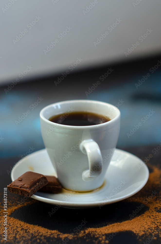 a cup of coffee with sprinkled coffee beans on the table