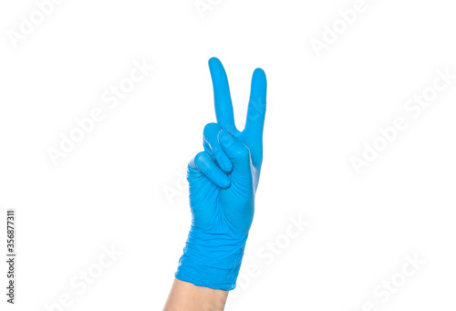 sign of victory and peace - a hand in a blue protective glove holds up two fingers