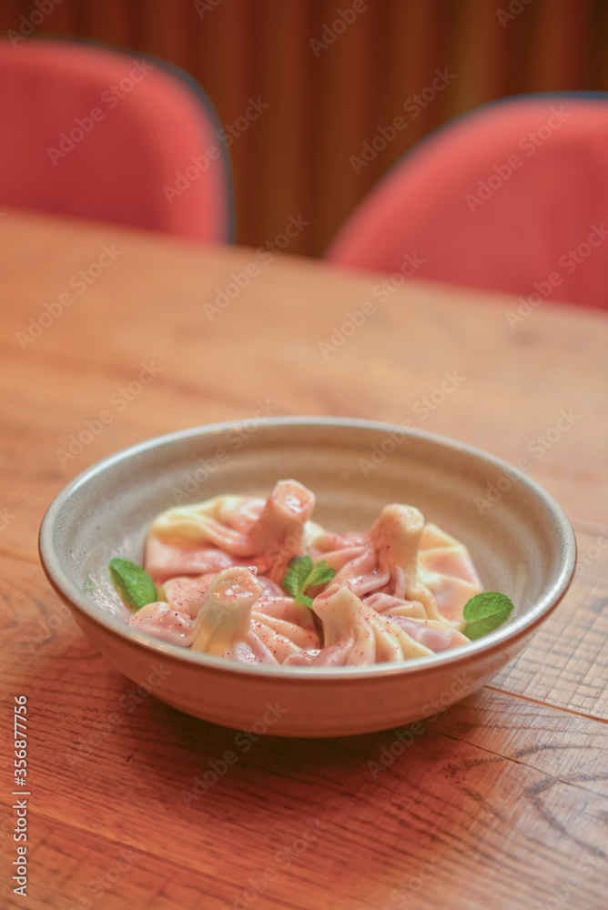 Sweet khinkali with cherry served on a wooden table. Traditional Georgian desserts. Georgian cuisine. Sweet khinkali with cherry served on a wooden table. Traditional Georgian desserts. Georgian cuisine.