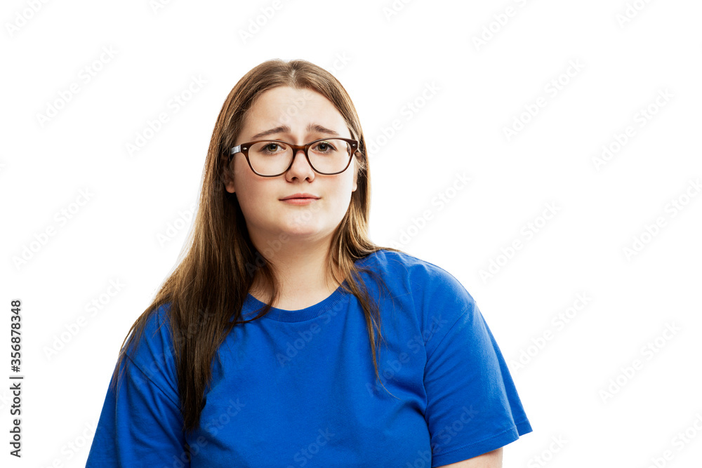 Fototapeta premium Young girl in glasses with a mournful face. Problems and helplessness. Isolated on a white background.