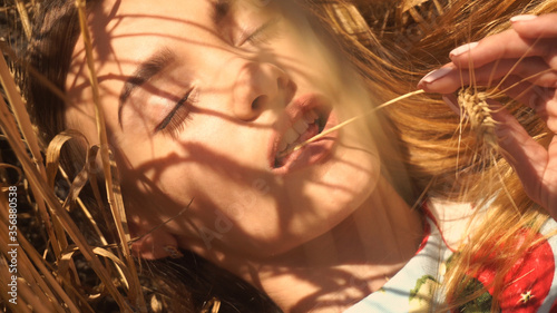 closeup portrait charming girl lies in a field of wheat