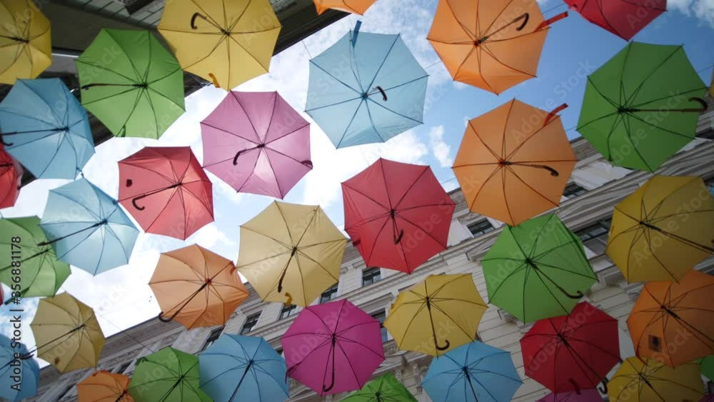 Colorful Umbrellas Hanging in the Air above the Street. Low angle rotating view Colorful Umbrellas Hanging in the Air above the Street. Low angle rotating view