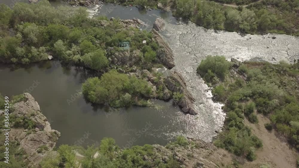 Aerial view to granite mountains, islands and rapids on Southern Bug river, surrounded by trees and grasses, Mihiia village. Ukraine. Famous place for rafting and kayaking Aerial view to granite mountains, islands and rapids on Southern Bug river, surrounded by trees and grasses, Mihiia village. Ukraine. Famous place for rafting and kayaking