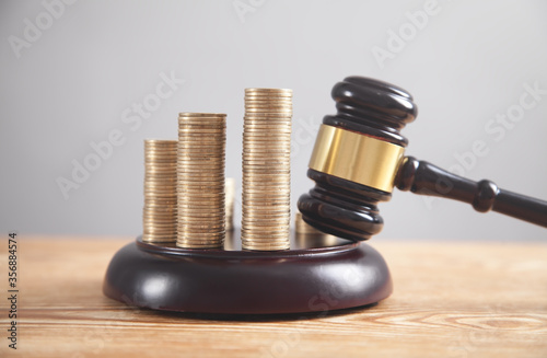 Photo Stack of coins with judge gavel.