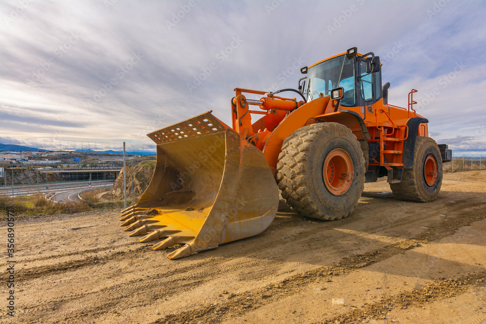 Fototapeta premium Excavator moving earth on a road construction works
