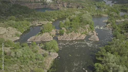 Aerial view to granite mountains and rapids on Southern Bug river, surrounded by trees and grasses, Mihiia village. Ukraine. Famous place for rafting and kayaking photo