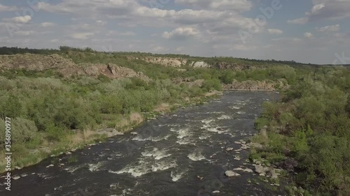 Aerial view to granite mountains and rapids on Southern Bug river, surrounded by trees and grasses, Mihiia village. Ukraine. Famous place for rafting and kayaking photo