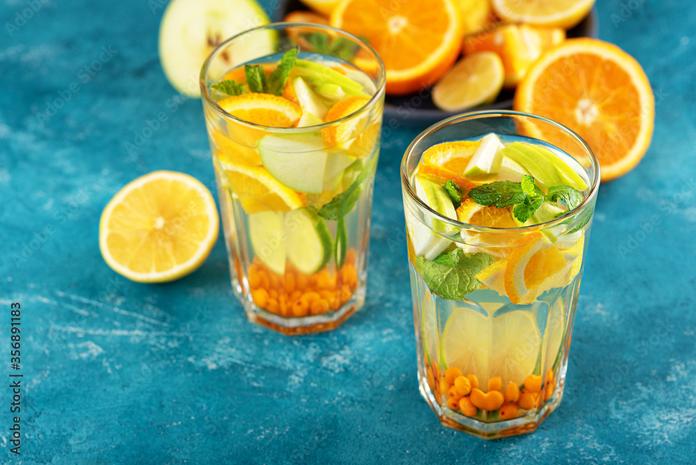 refreshing detox water with lemon, orange, mint in glasses on blue background refreshing detox water with lemon, orange, mint in glasses on blue background