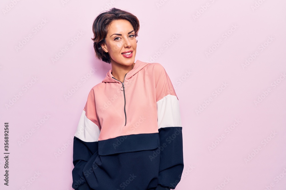 Young beautiful woman wearing sportswear looking positive and happy standing and smiling with a confident smile showing teeth Young beautiful woman wearing sportswear looking positive and happy standing and smiling with a confident smile showing teeth