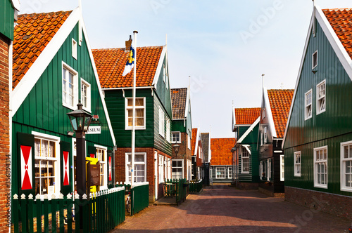 Netherlands, North Holland. Typical for the peninsula of Marken wooden green houses on Kerkbuurt street and the Marken Museum of Local Lore photo