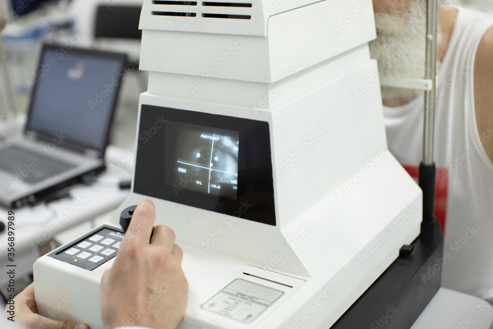Doctor Optometrist examining bearded senior man eyes with special eye equipment. Doctor Optometrist examining bearded senior man eyes with special eye equipment.